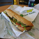 Subway footlong unwrapped on a tray at a Subway restaurant table